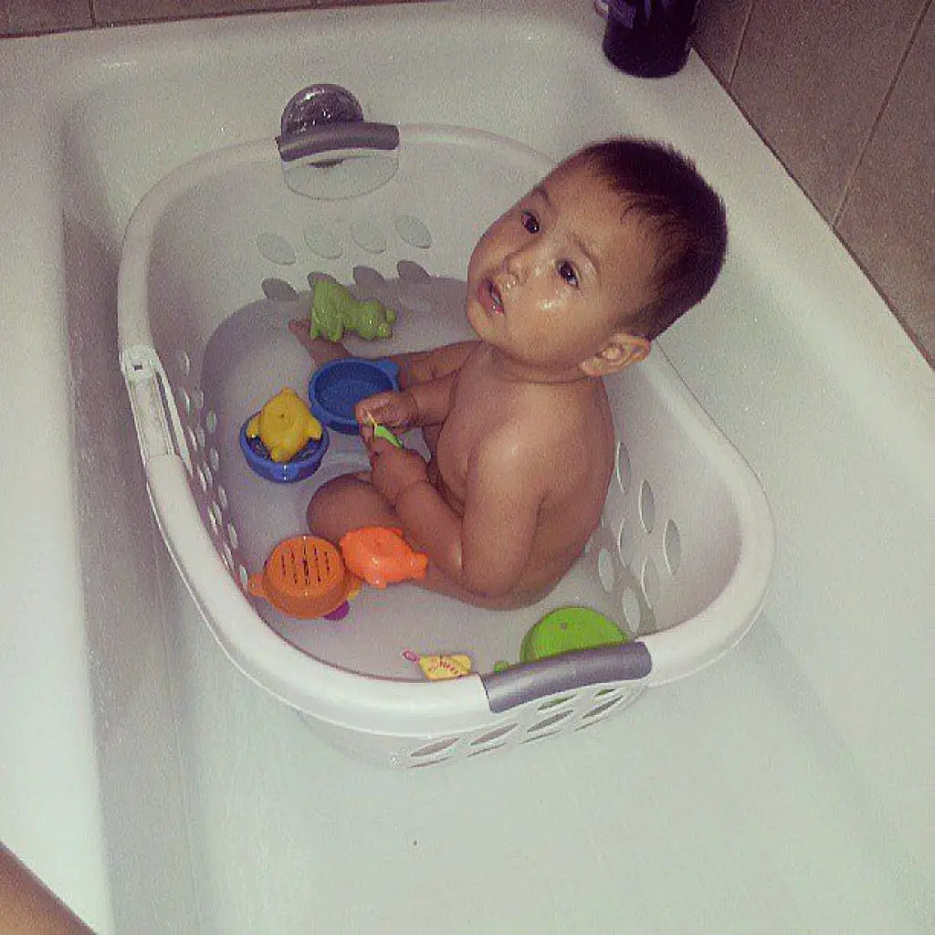 baby in a laundry basket in the tub