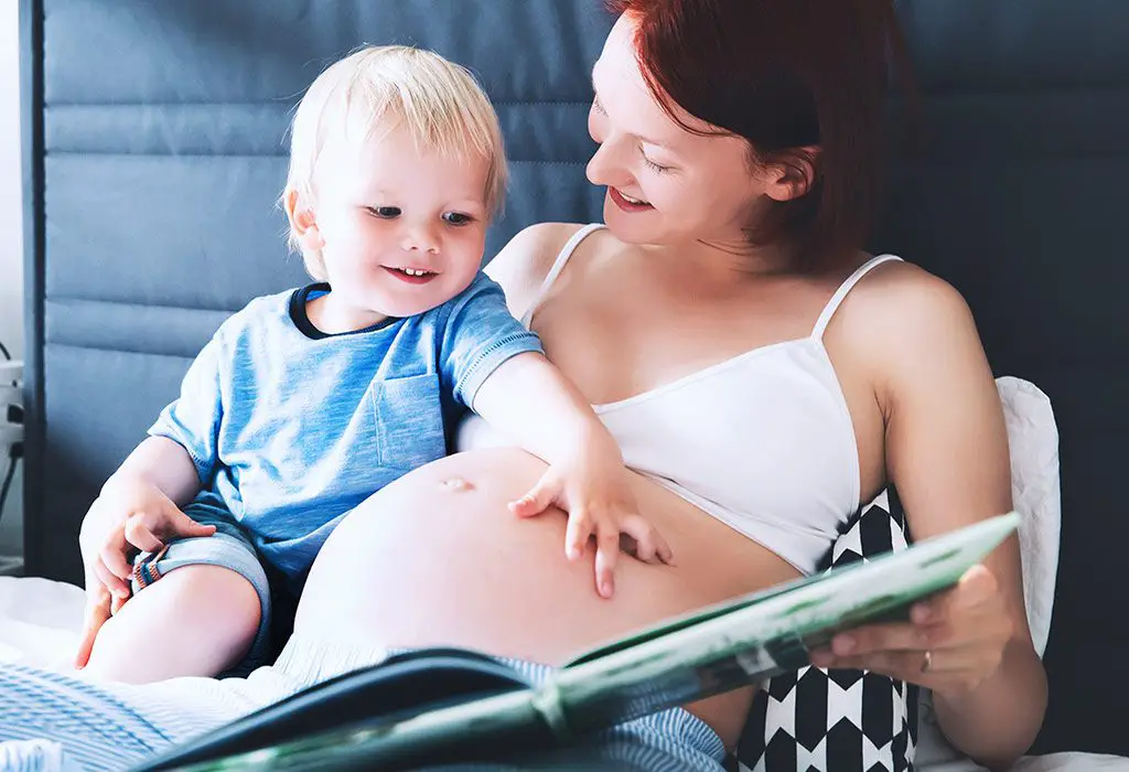 Mom to be reading to her son about the new baby